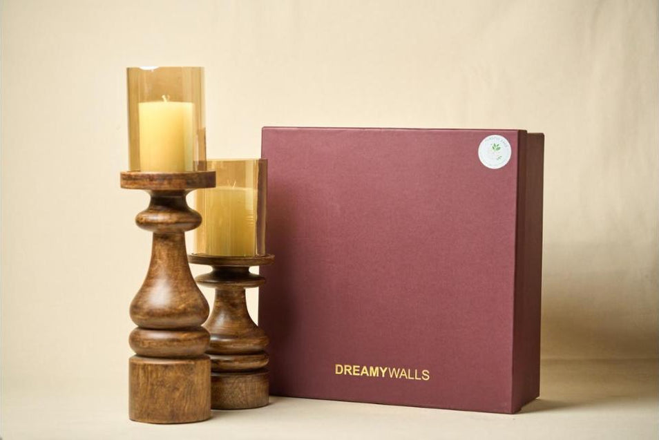 Wooden pillar candle stands with amber glass beside the DREAMYWALLS gift box